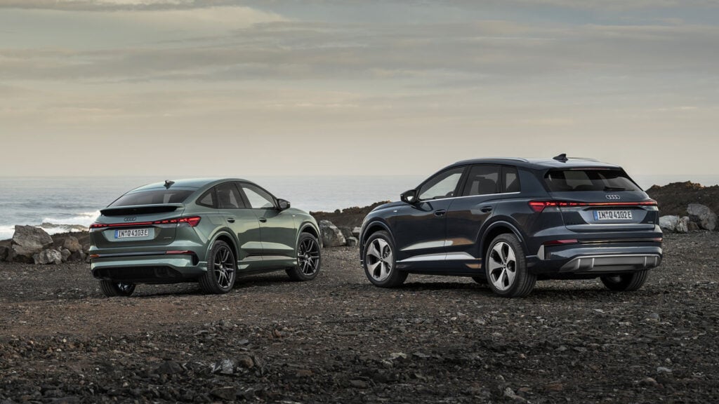 Audi Q4 e-tron Sportback och SUV bredvid varandra på terrängunderlag.