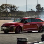 Röd Audi RS 5 sladdar genom en kurva på en motorbana.