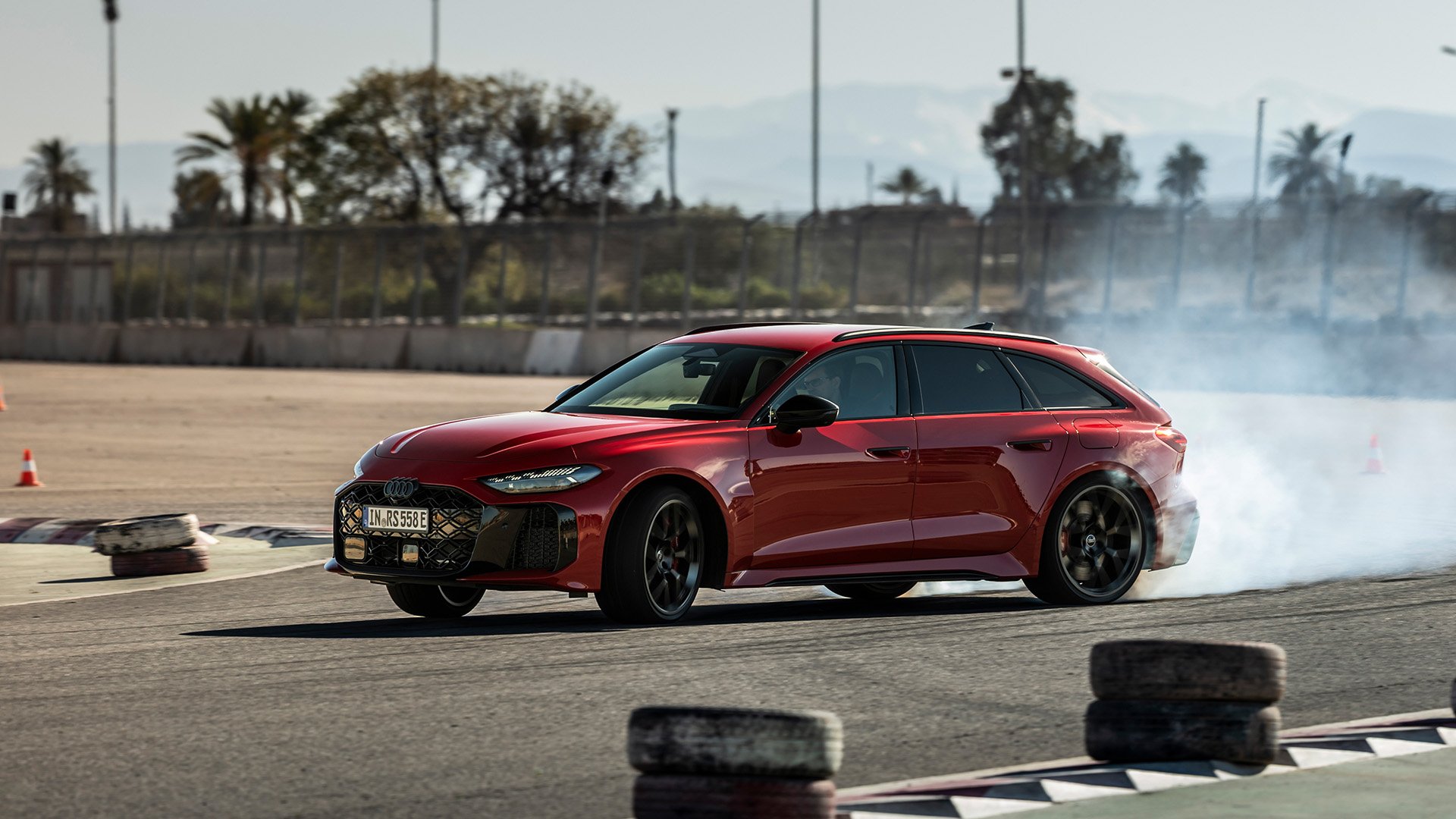 Röd Audi RS 5 sladdar genom en kurva på en motorbana.