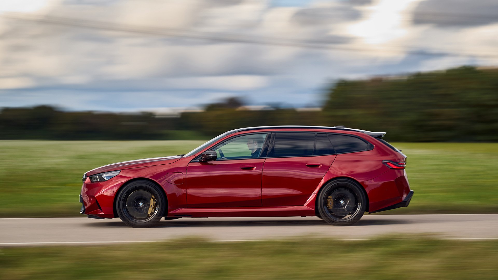 Röd BMW M5 Touring i profil.
