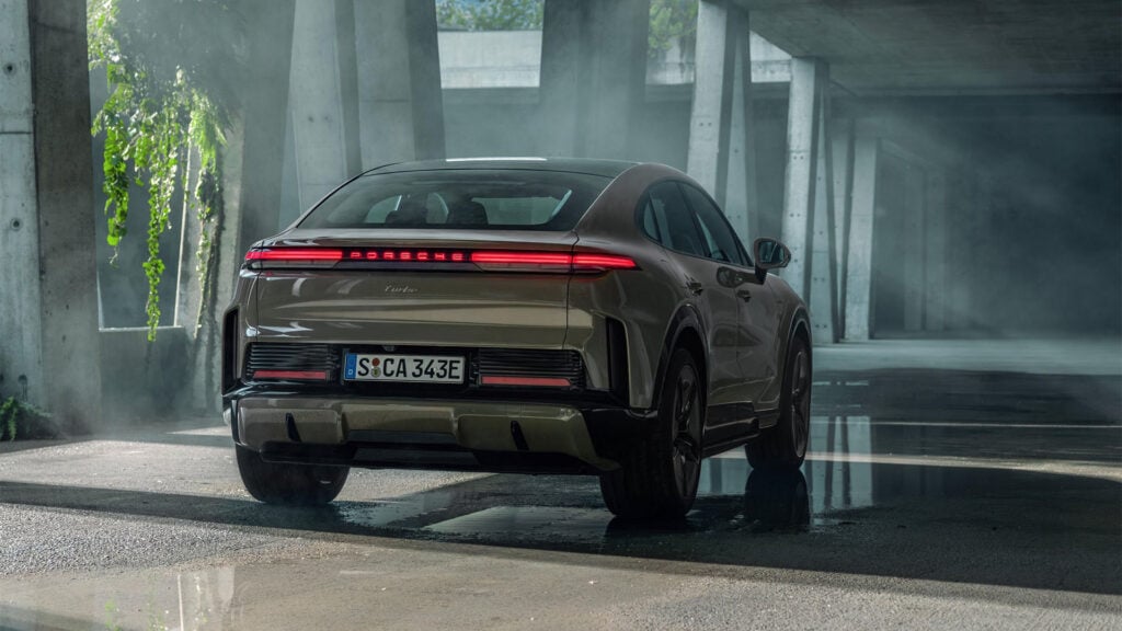 Grön Porsche Cayenne Coupé Electric snett bakifrån i betongmiljö.