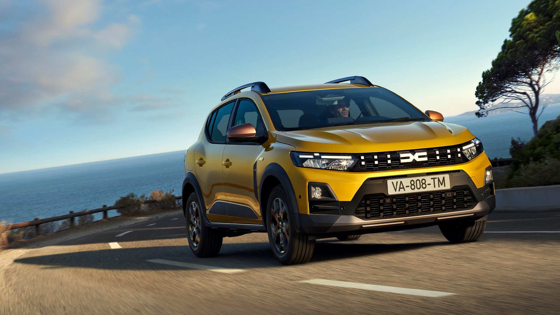 Gul Dacia Sandero Stepway på landsväg.