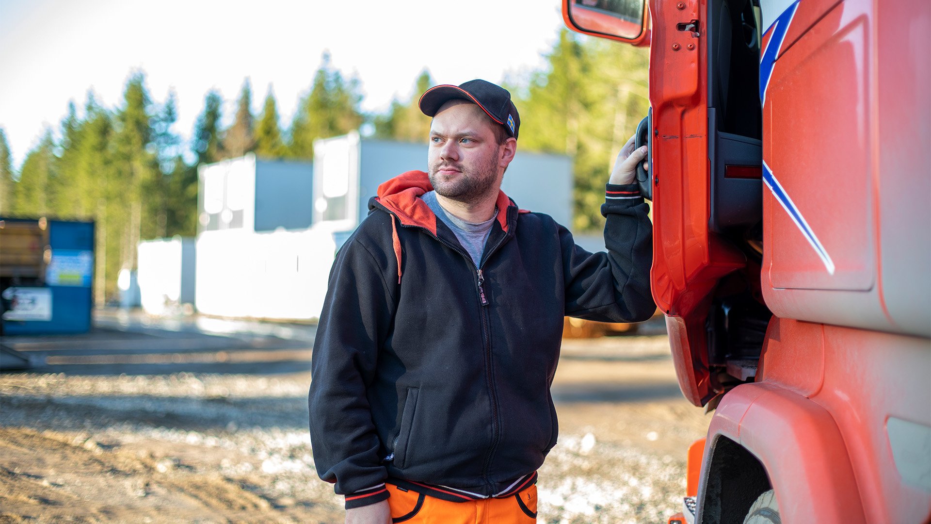 Lastbilschaufför står bredvid en lastbil.
