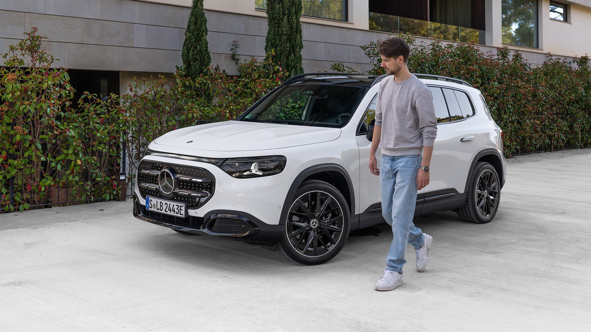 Vit Mercedes-Benz GLB med John Sempill gåendes vid bilen.