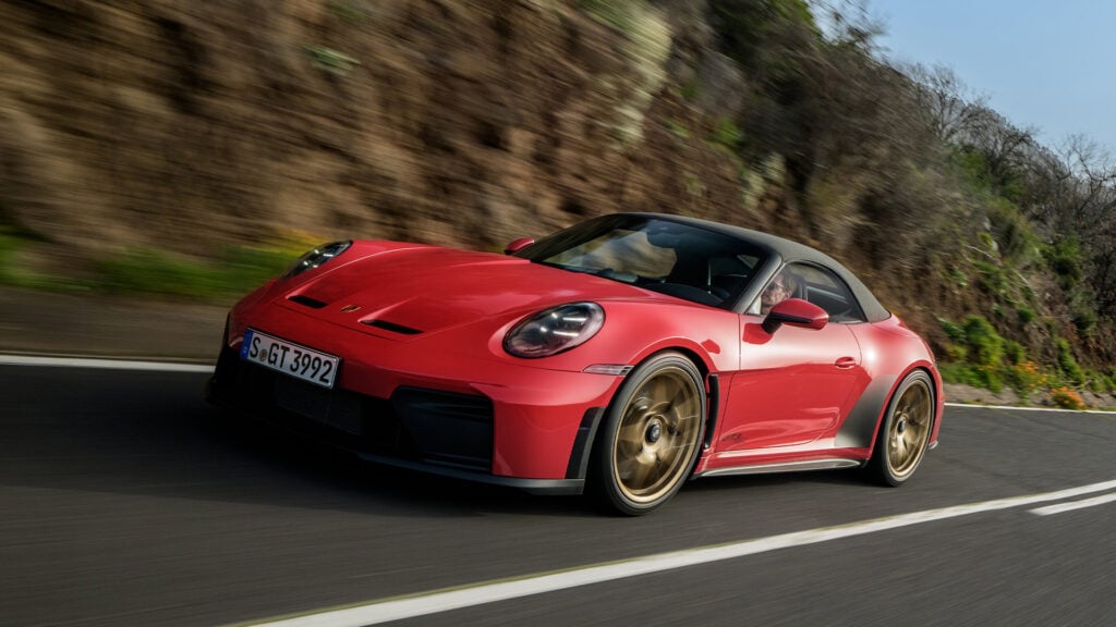 Röd Porsche 911 GT3 S/C snett framifrån på landsväg med suffletten uppe.