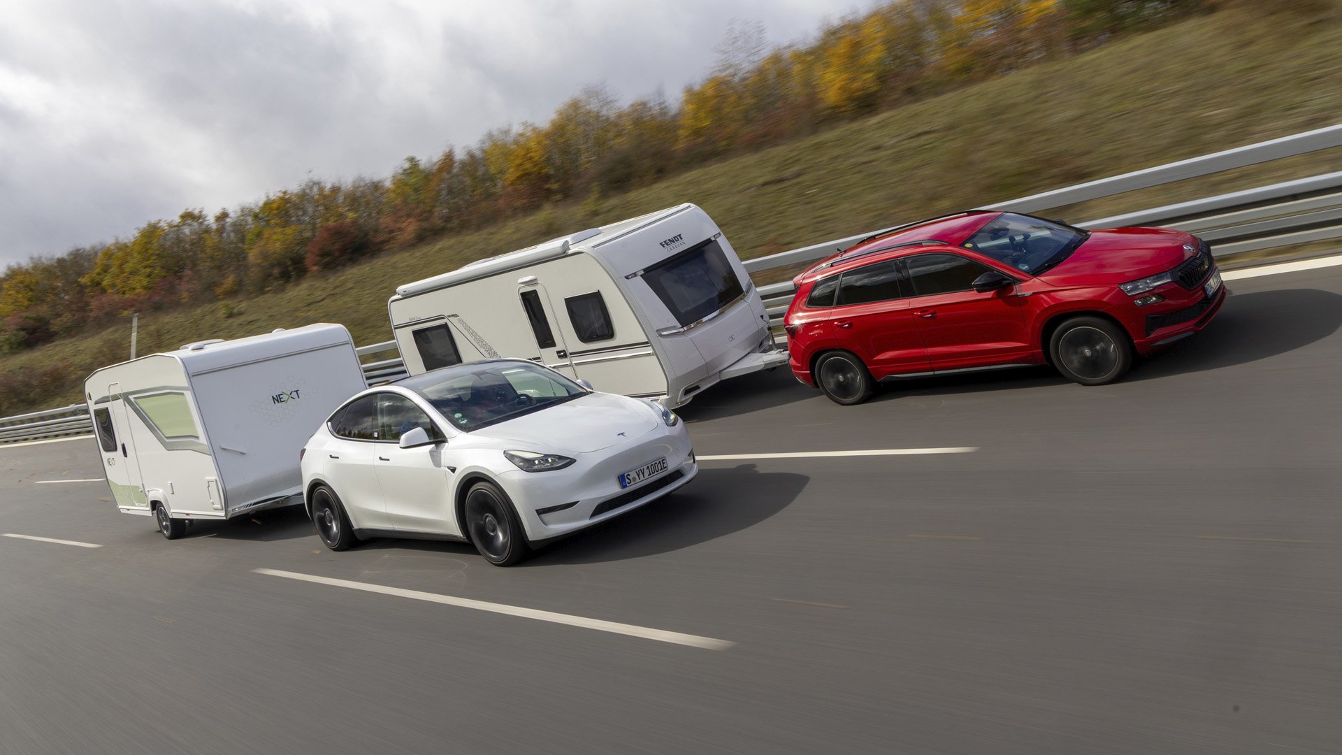 En vit Tesla Model Y och en röd Skoda Karoq drar varsin husvagn.