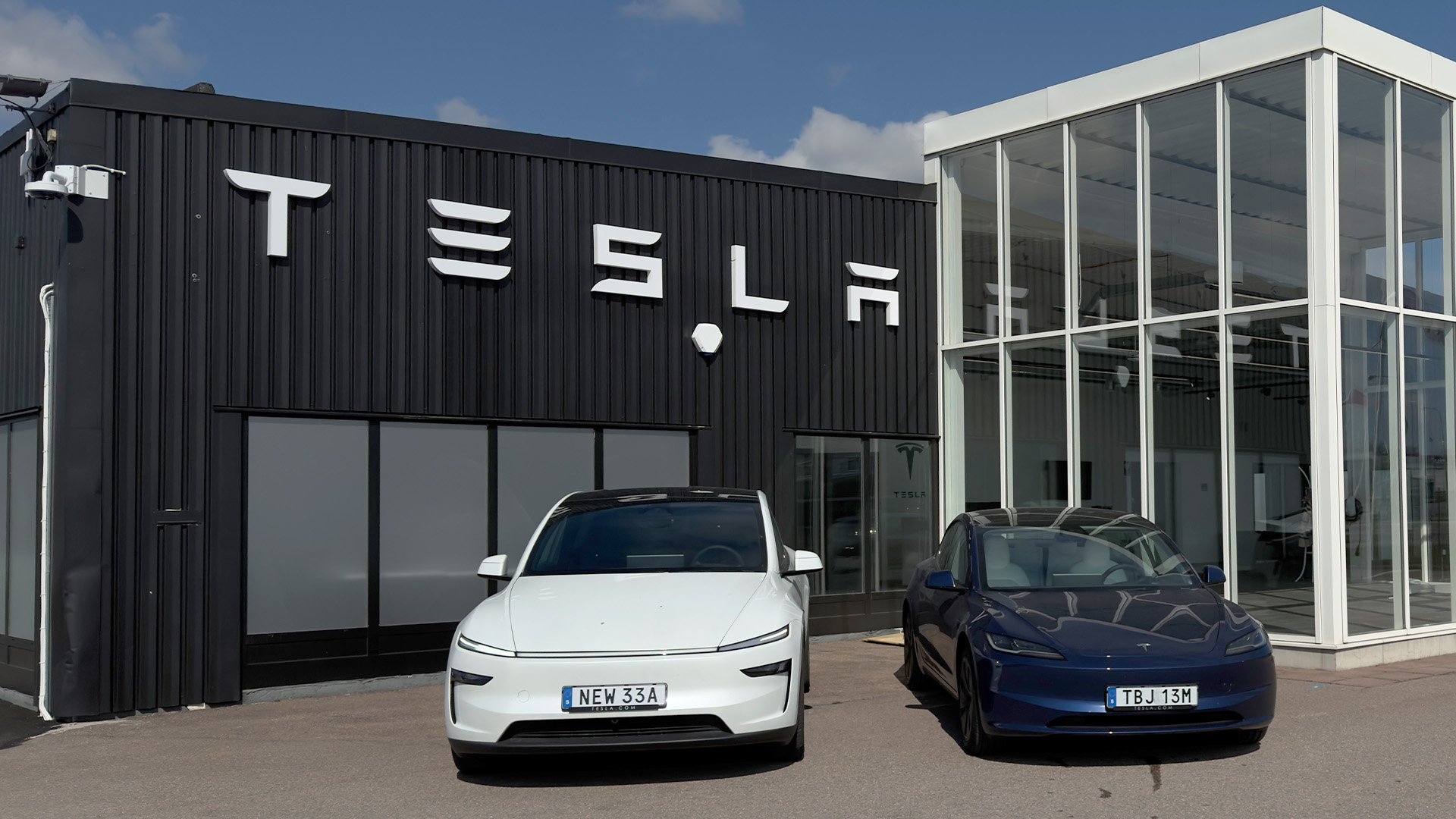 En Tesla Model Y och Model 3 står framför det nya servicecentret i Kalmar.