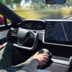 Tesla Model S kör autonomt med en förare med händerna på knäna.