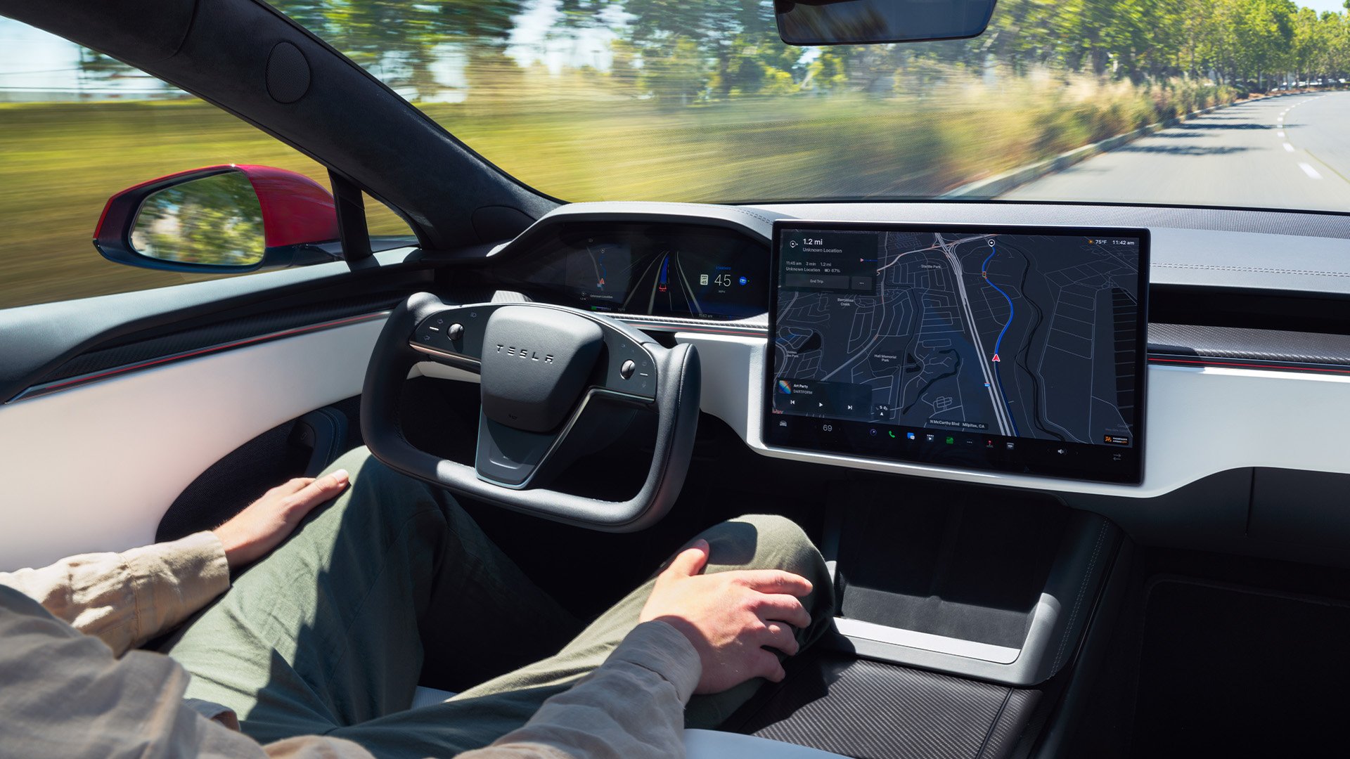 Tesla Model S kör autonomt med en förare med händerna på knäna.