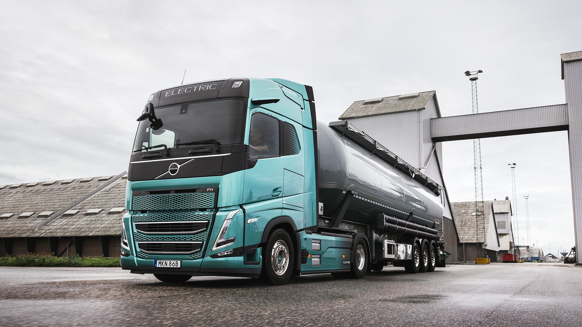 Grön Volvo FH Aero med tanklast snett framifrån.