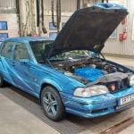 Volvo S70 som elbil med huven öppen i en besiktningshall.