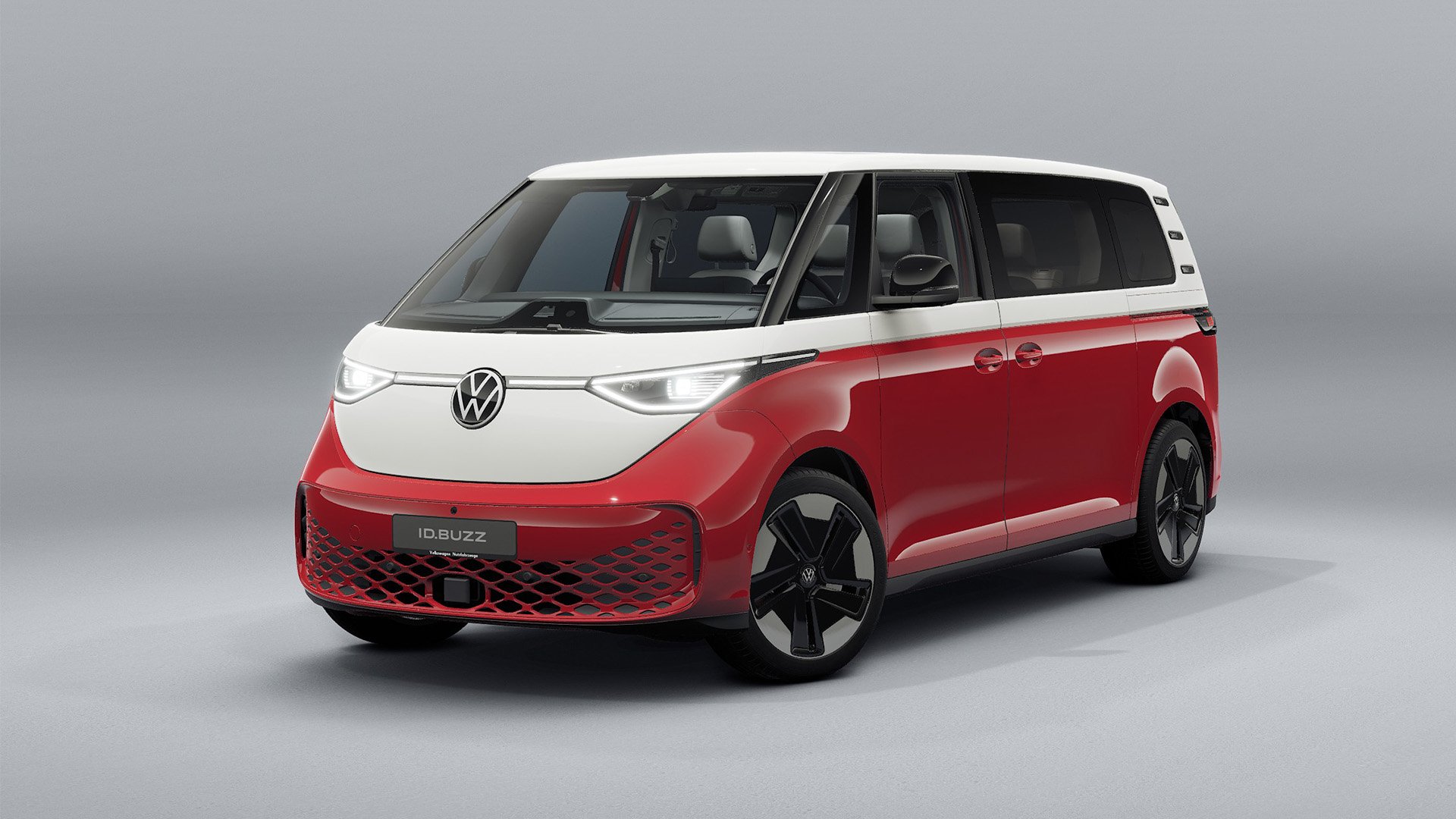 Vit och röd VW ID. Buzz 4Motion snett framifrån i studiomiljö.