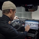 En Zeekr 7GT över axeln på föraren som tittar på mittdisplayen.