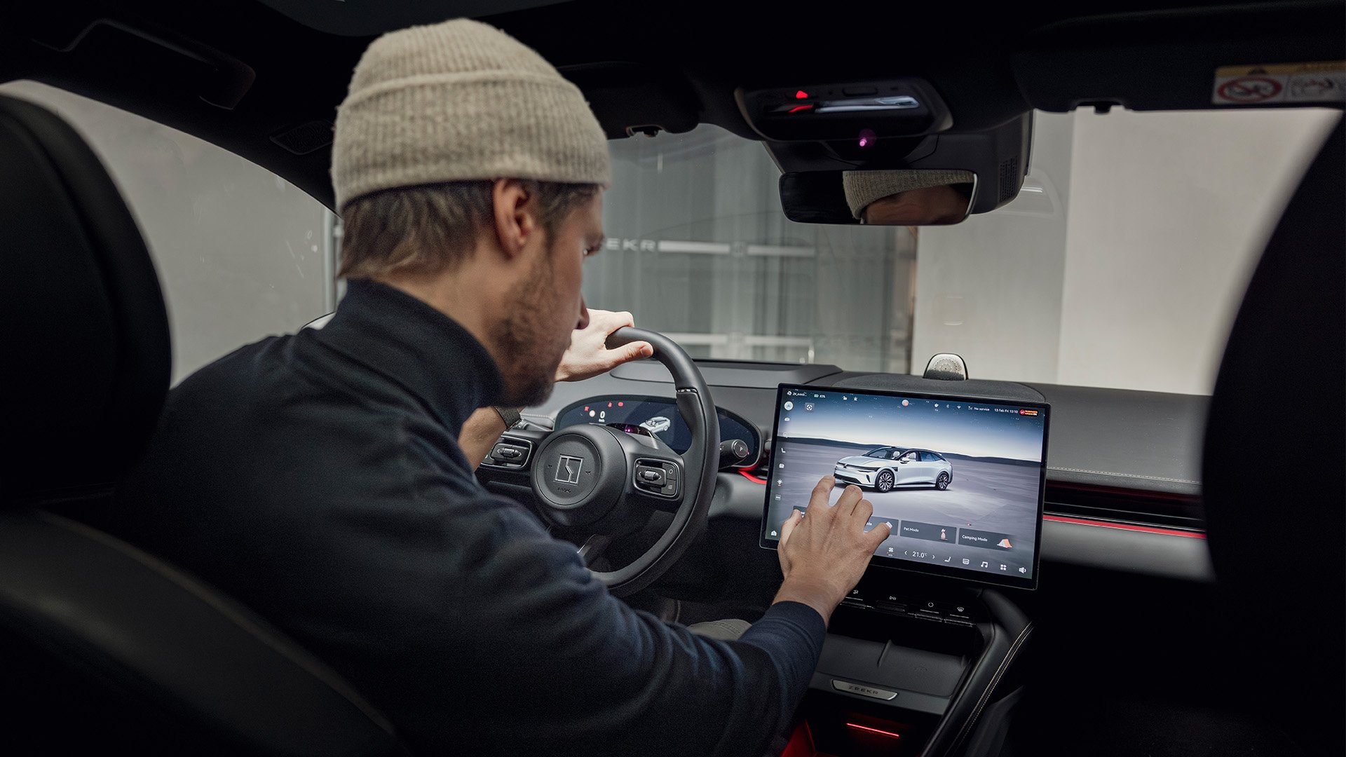 En Zeekr 7GT över axeln på föraren som tittar på mittdisplayen.