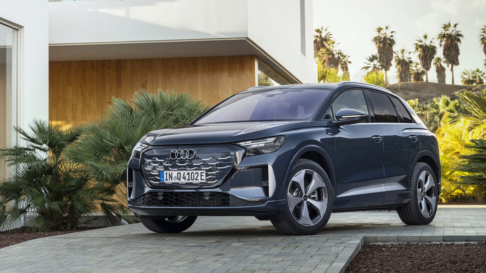 Blå Audi Q4 e-tron framför en villa.