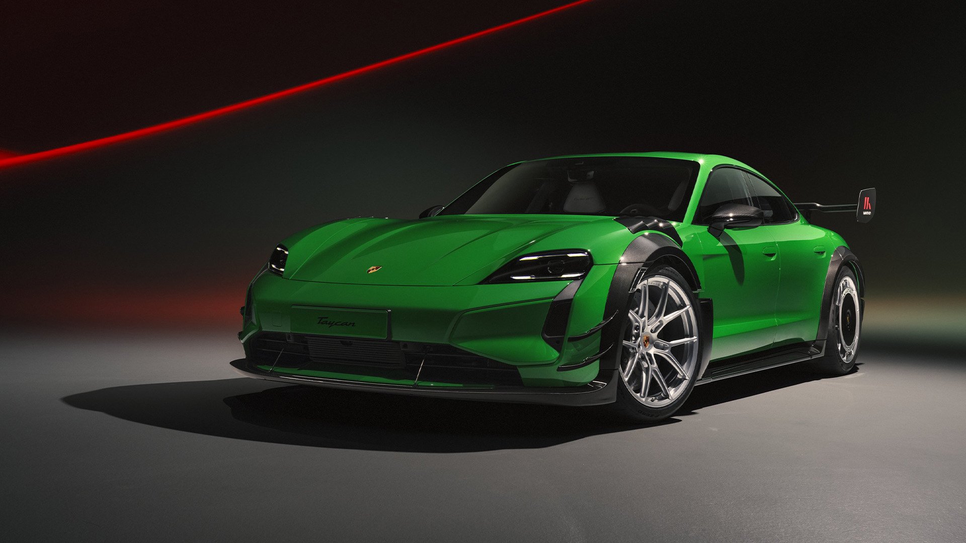 Grön Porsche Taycan Turbo GT med Manthey Kit snett framifrån i studio.