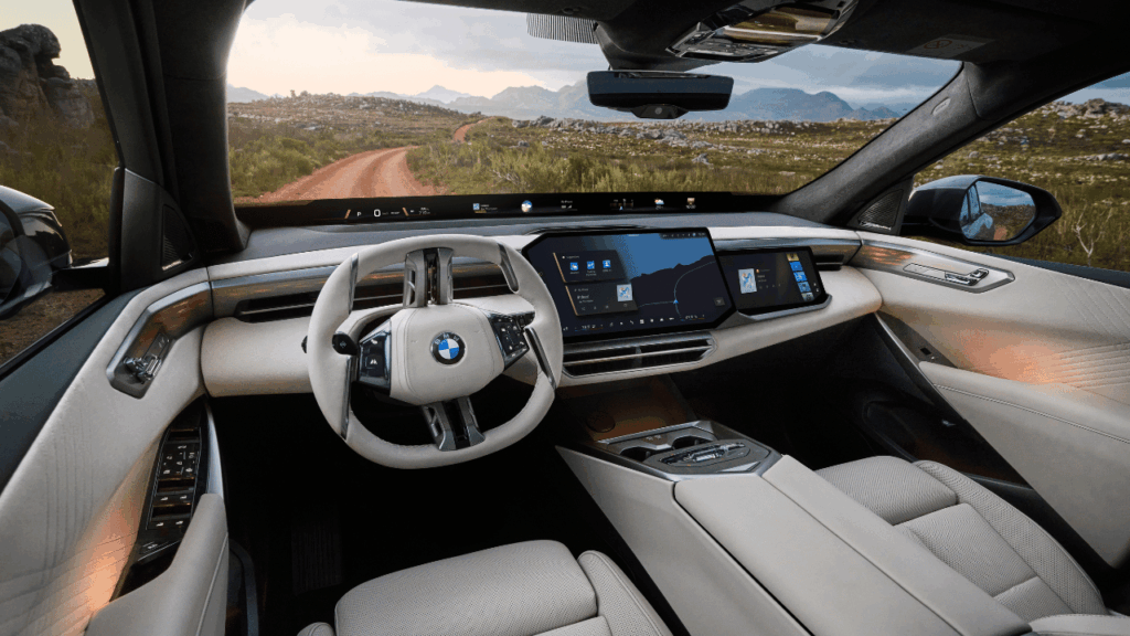 Cockpit i elsuven iX5, där ”BMW Panoramic Vision” projicerar all viktig kördata direkt längs vindrutans nedre kant. Foto: BMW