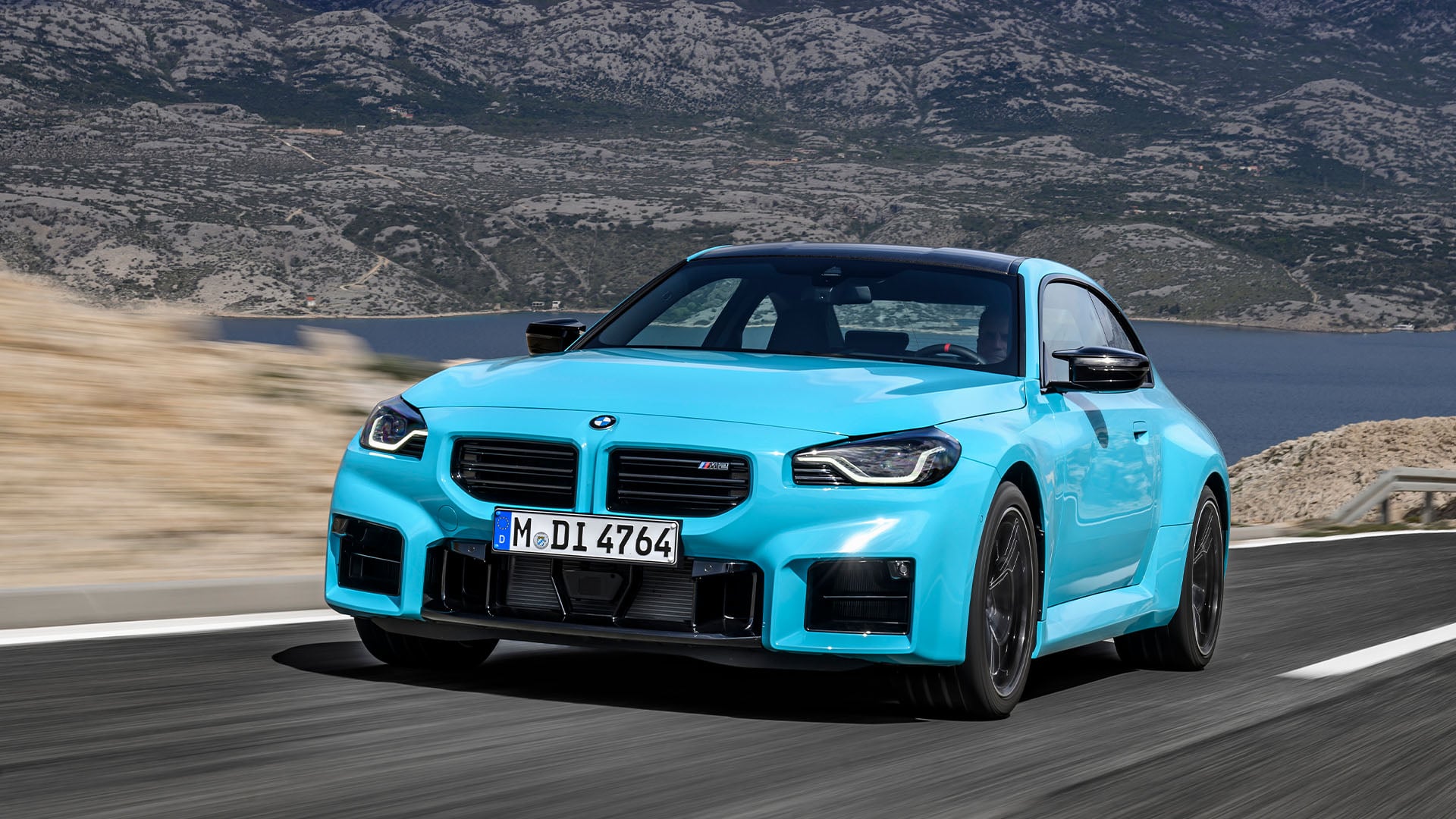 Blå BMW M2 snett framifrån på väg.