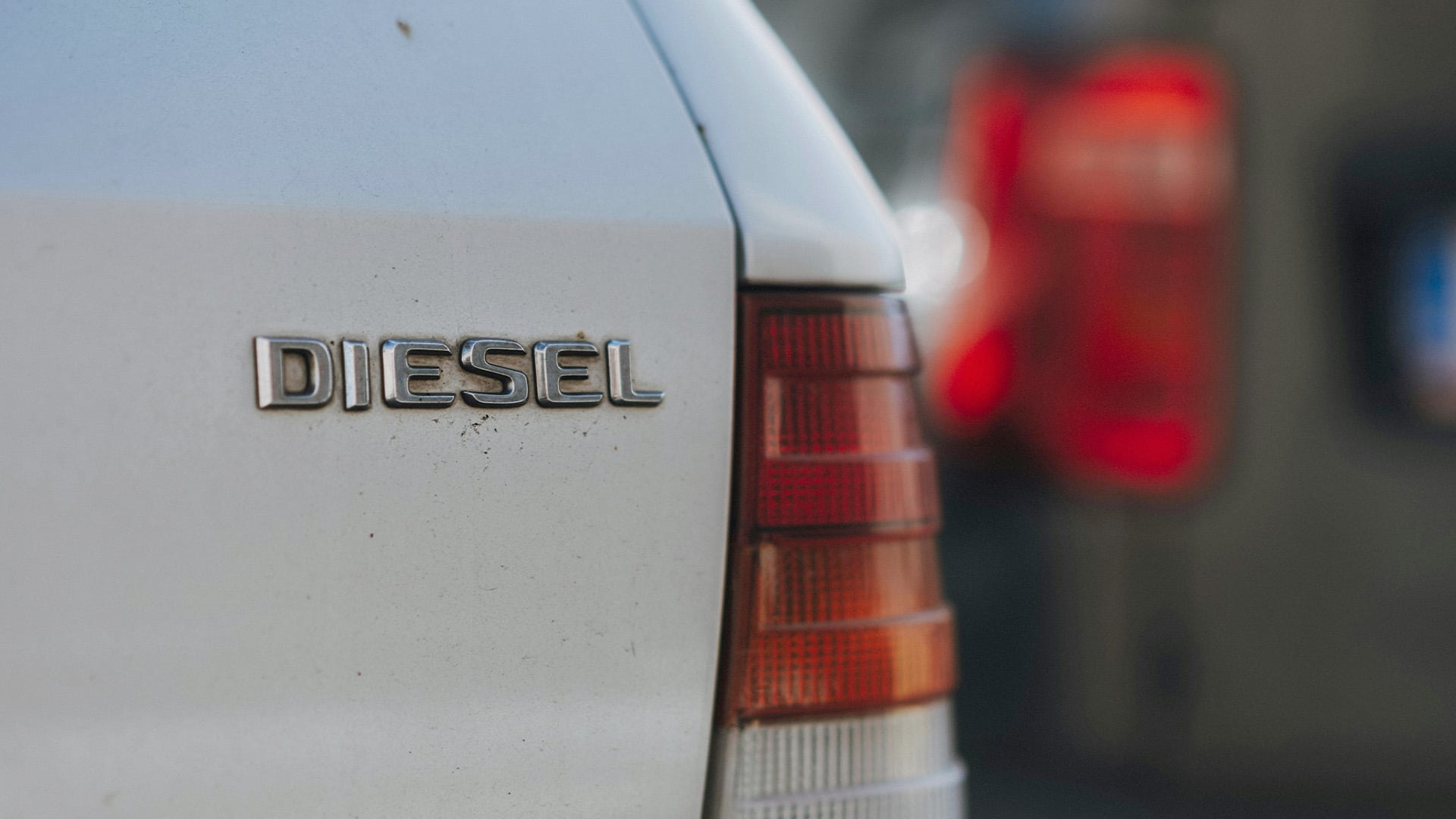 Diesel-emblem i närbild på baklucka till en vit Mercedes-Benz.