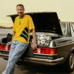 Henrik Larsson iklädd en Adidas-VM-tröja lutar mot en Mercedes-Benz W123.