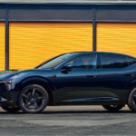 Svart Xpeng L03 framför ett gult garage.
