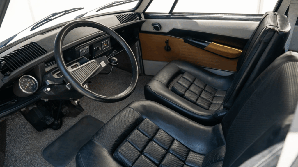 Förarmiljön är minimalistisk men funktionell. Den tunna ratten och den grå nålfiltsmattan var standard, liksom de kraftigt skålade svarta vinylstolarna. Foto: Broad Arrow Auctions