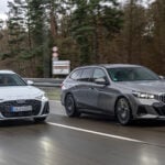 Audi A6 Avant och BMW 530e på väg med skog i bakgrunden.