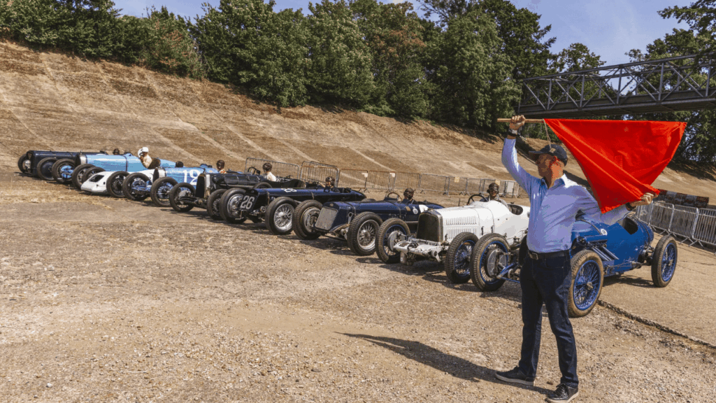 Exakt på minuten 100 år efter starten 1926 återskapades startuppställningen på originalgriden framför den ikoniska bankade kurvan. Foto: Brooklands Museum