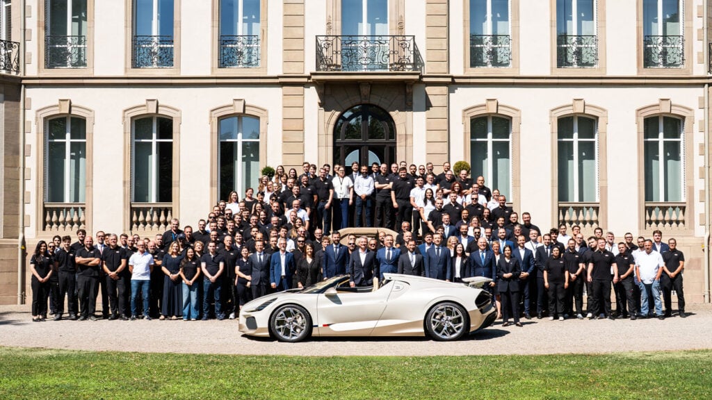 Vit Bugatti W16 Mistral framför hela teamet.