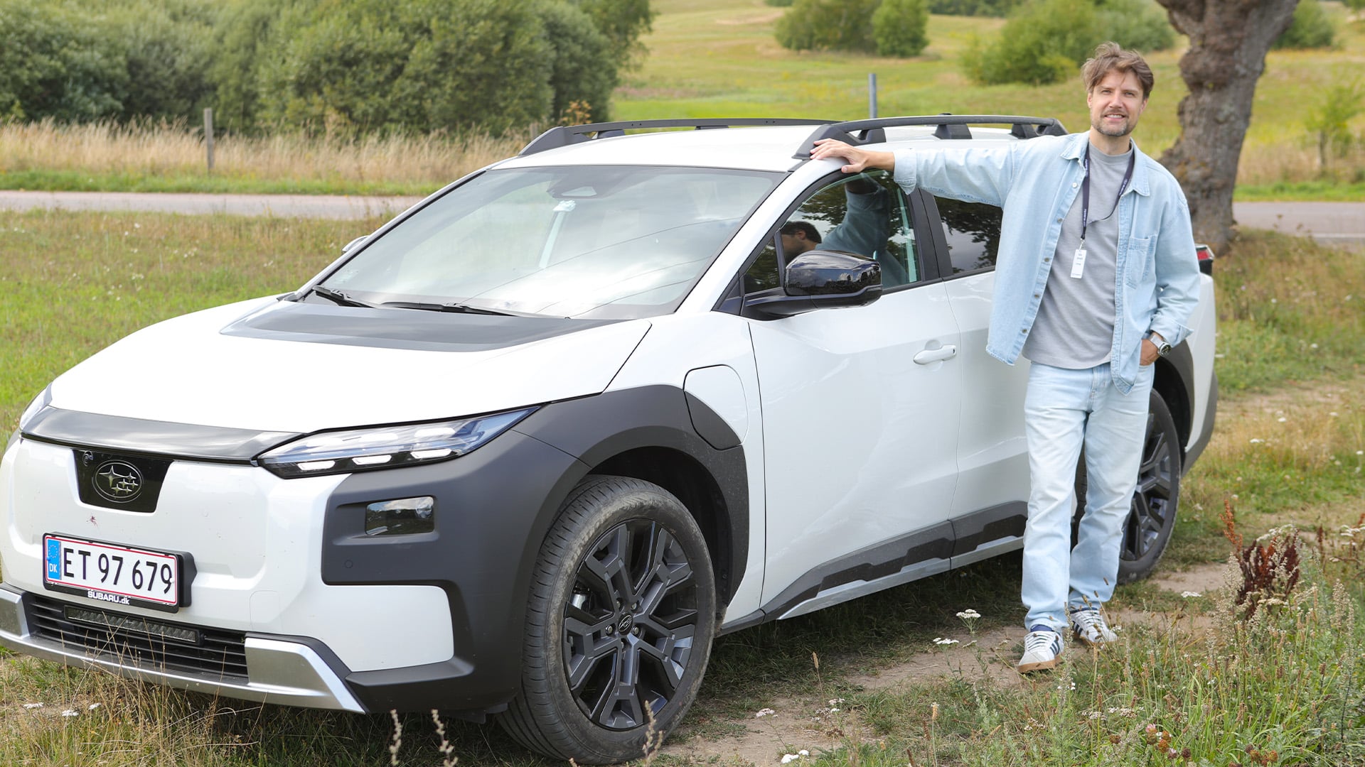 Vit Subaru E-Outback med John Sempill bredvid.