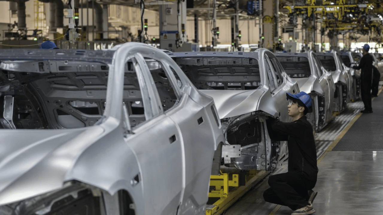 En bilarbetare kontrollerar karossen på en elbil hos Geely, vars märken som Volvo och Polestar står på tur för de nya fastfasbatterierna. Foto: Geely