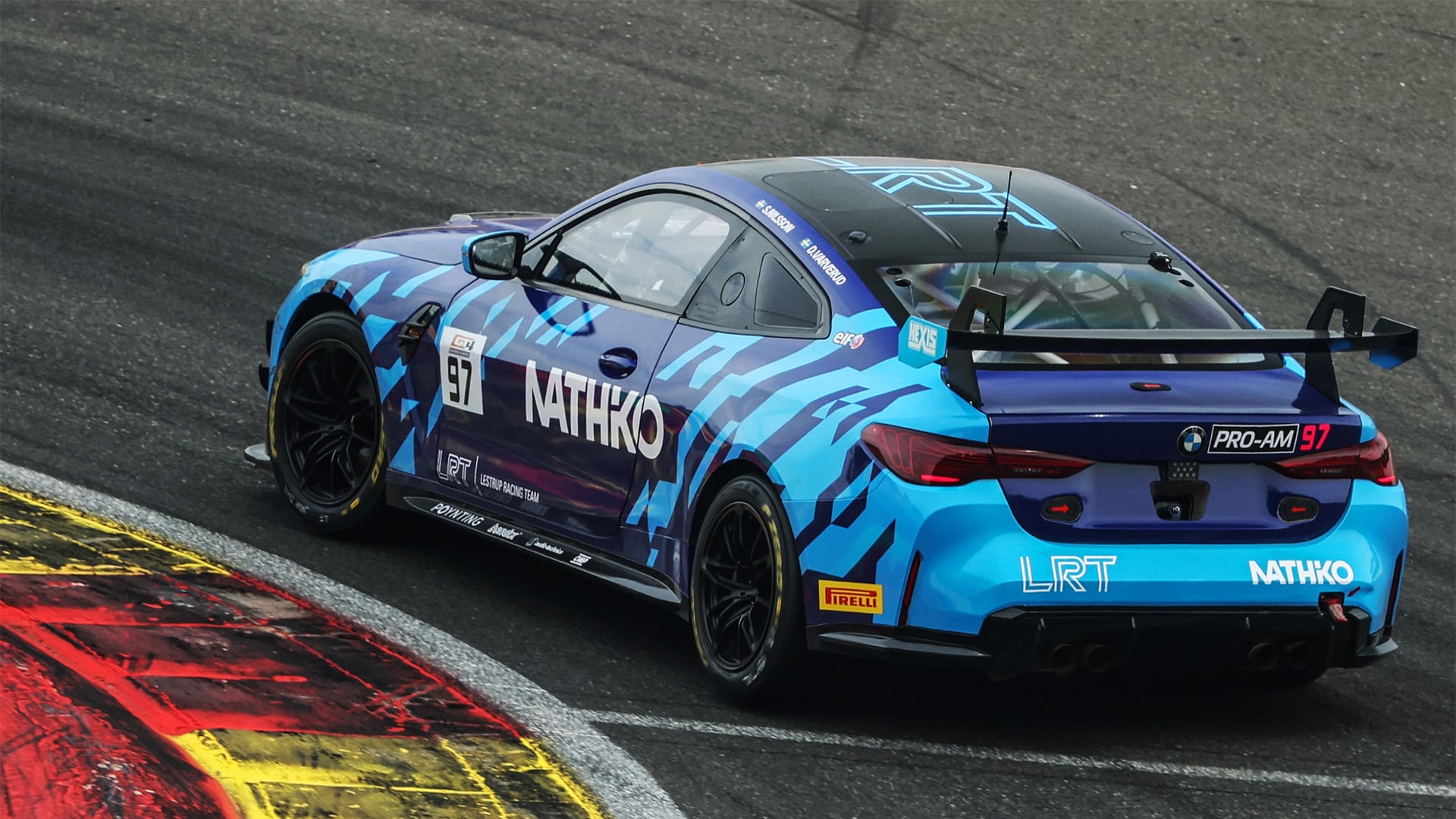 BMW GT4 Lestrup Racing Team på bana vid en curb.