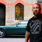 Jan Emanuel inklippt framför en grön Jaguar XJS.