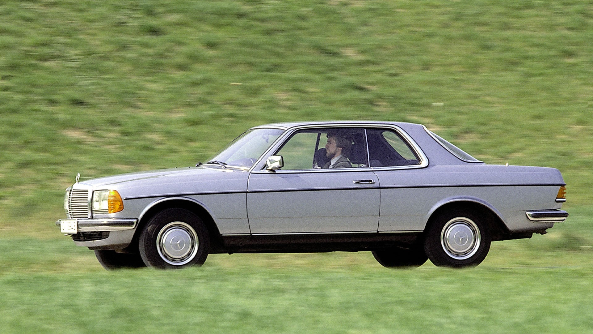 Grå Mercedes-Benz coupé i C 123-modellserien (1977–1985).