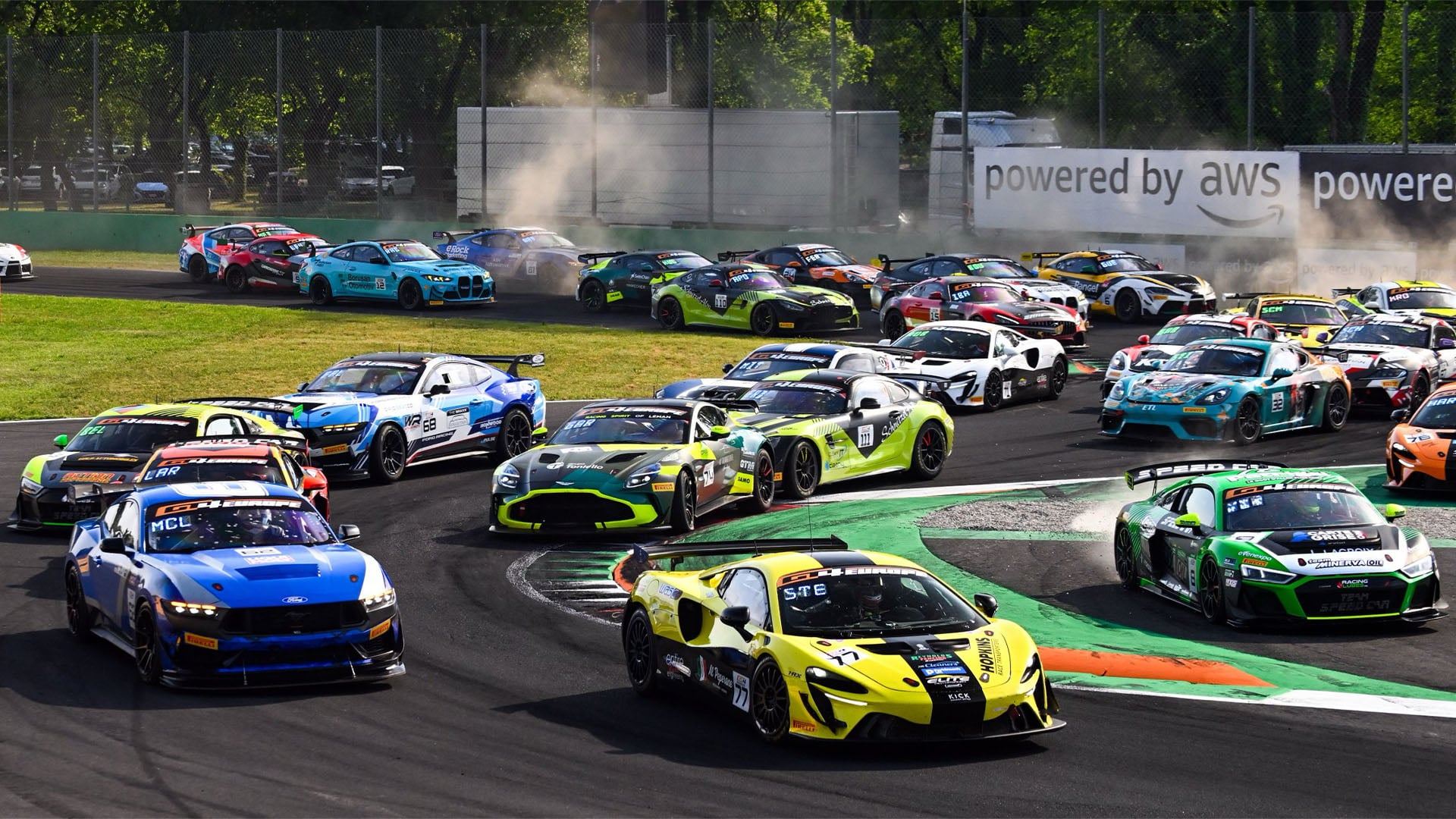 Många GT4-bilar kämpar om position på en motorbana.
