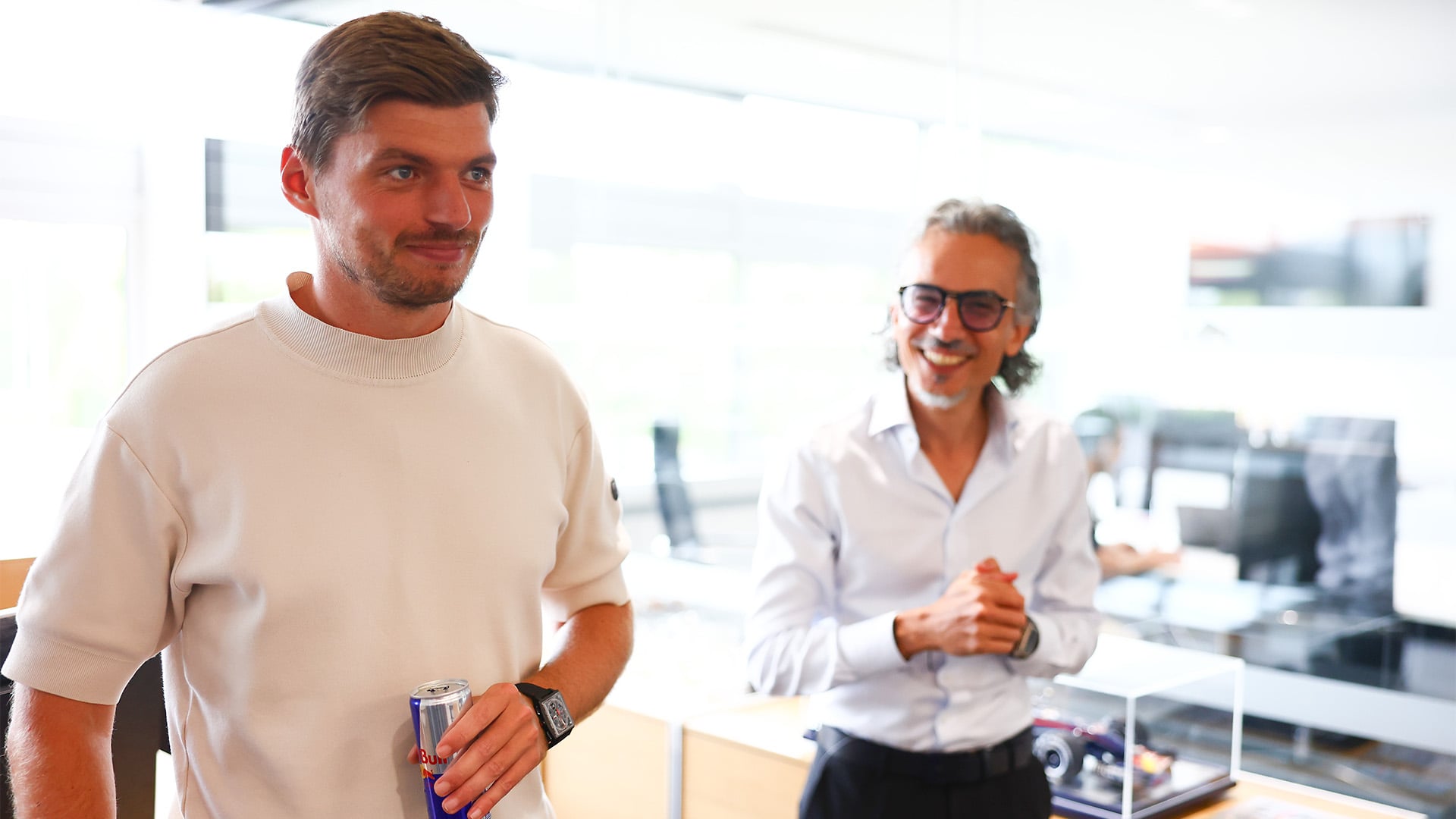 Max Verstappen till vänster håller en Red Bull-burk och Laurent Mekies står till höger och ler.