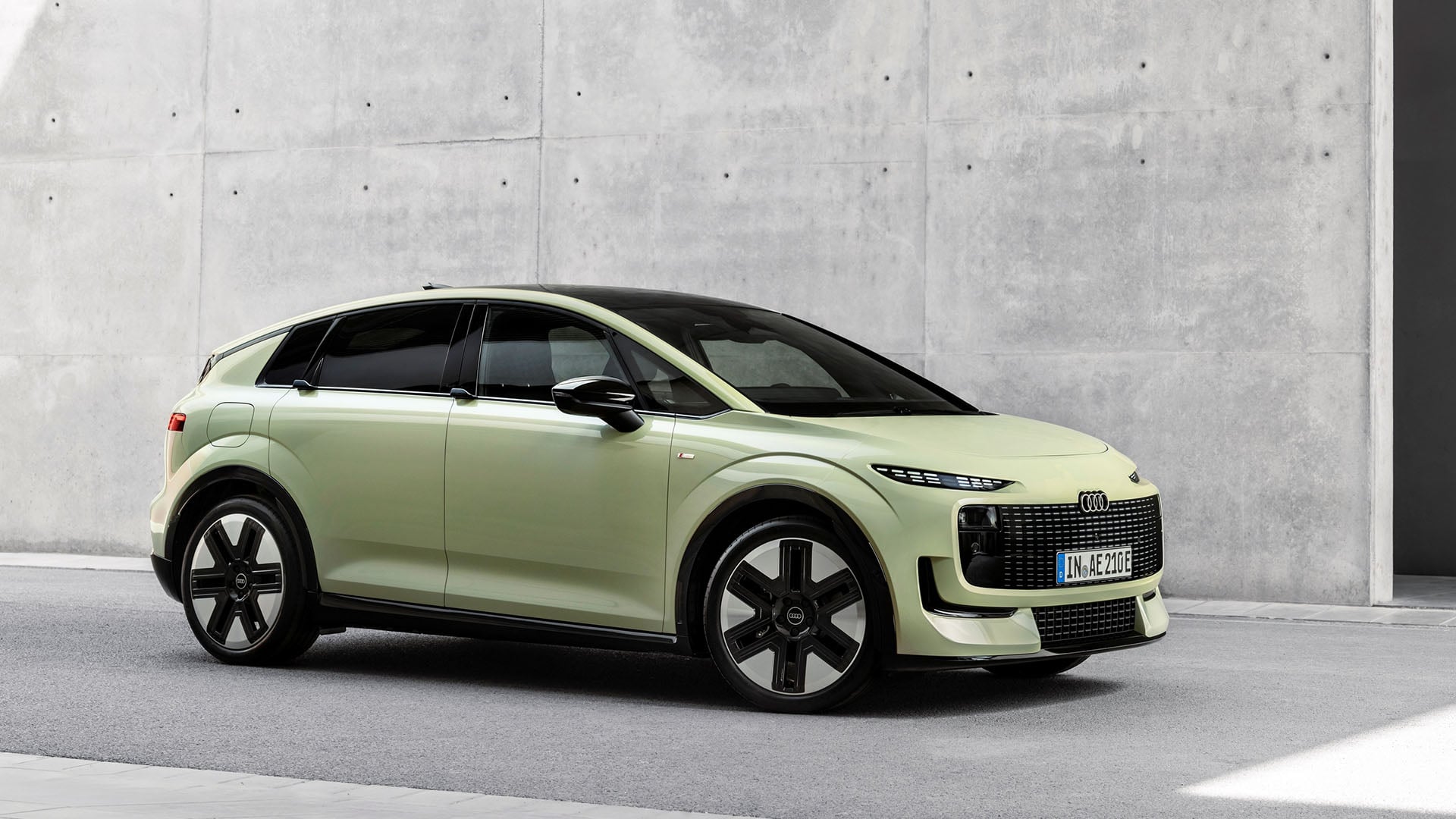 Audi A2 e-tron trekvartsvy mot betongbakgrund.