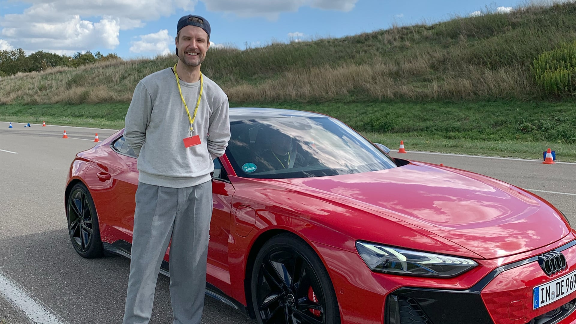 John Sempill framför en röd Audi S6 e-tron i Neuburg.