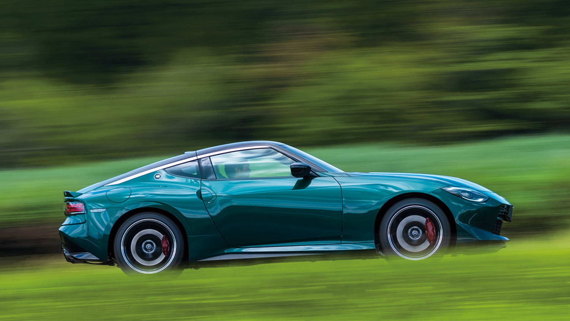 Grön Nissan Fairlady Z Nismo i profil på landsväg.