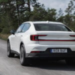 Vit Polestar 2 bakifrån på skogsväg.
