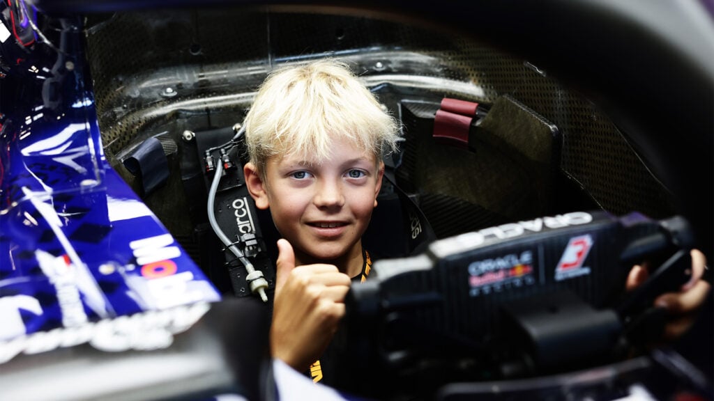 Robin Räikkönen sitter i en Red Bull F1-bil och ger tummen upp till kameran.