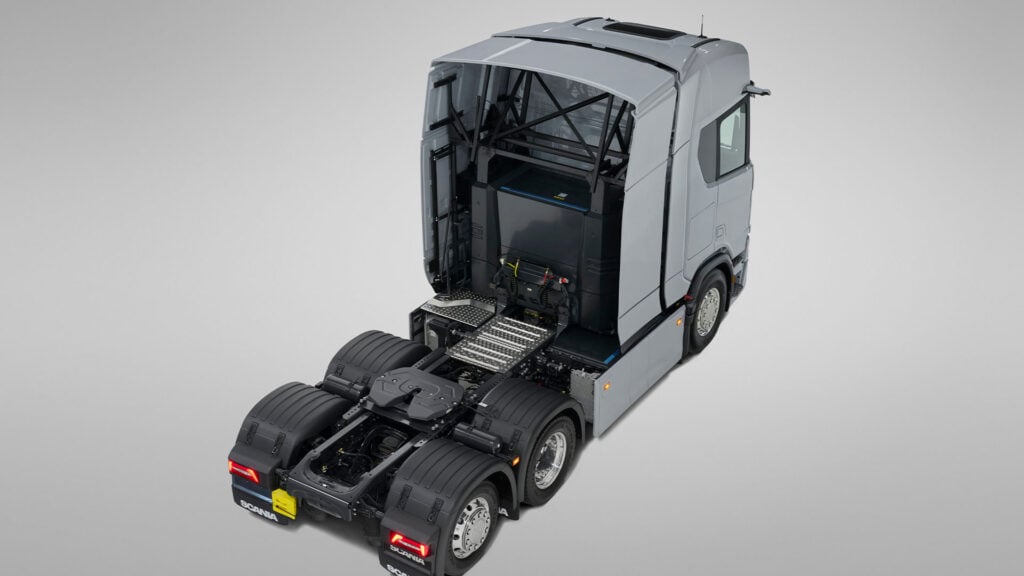 Grå elektrisk Scania lastbil utan släp med batteripaket synligt bakom hytten.