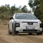 Vit Subaru E-Outback på terrängbana framifrån.