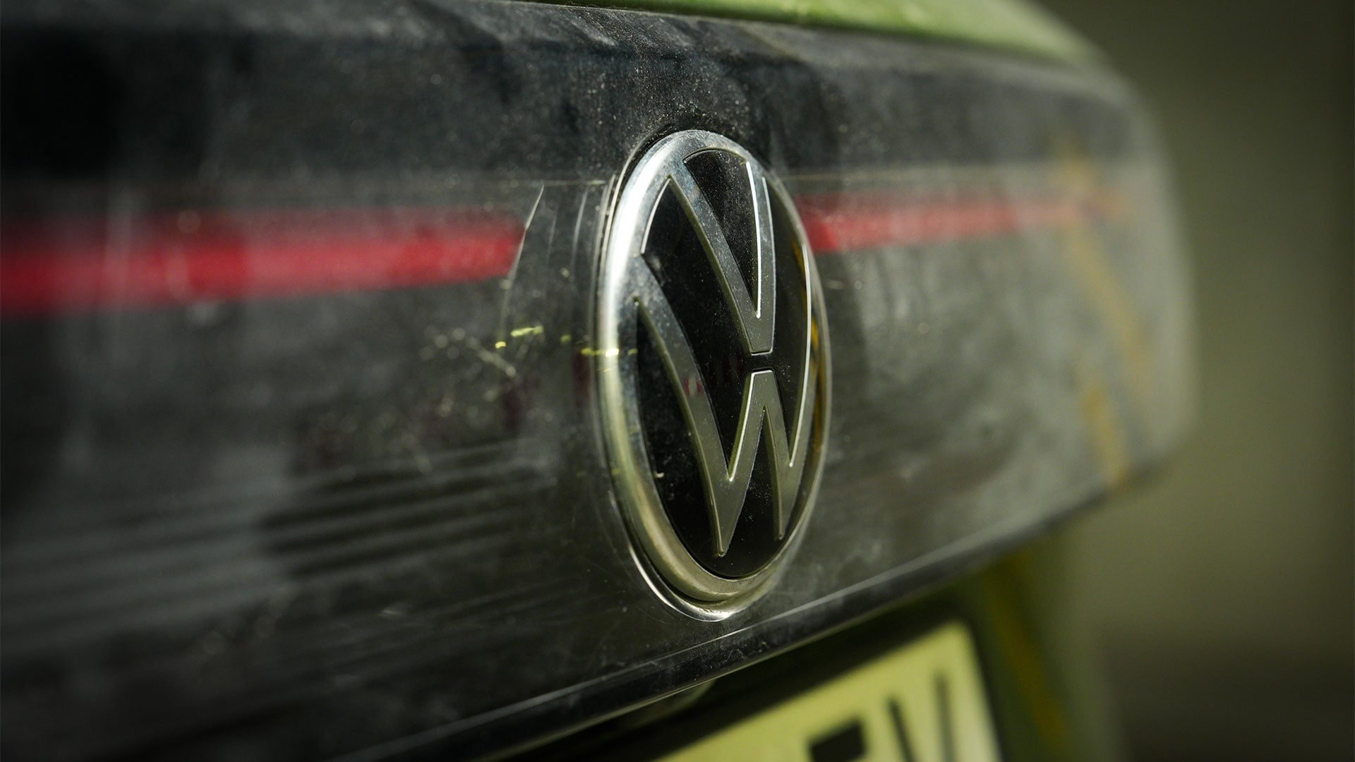 Smutsigt Volkswagen-emblem på en lika smutsig bil.