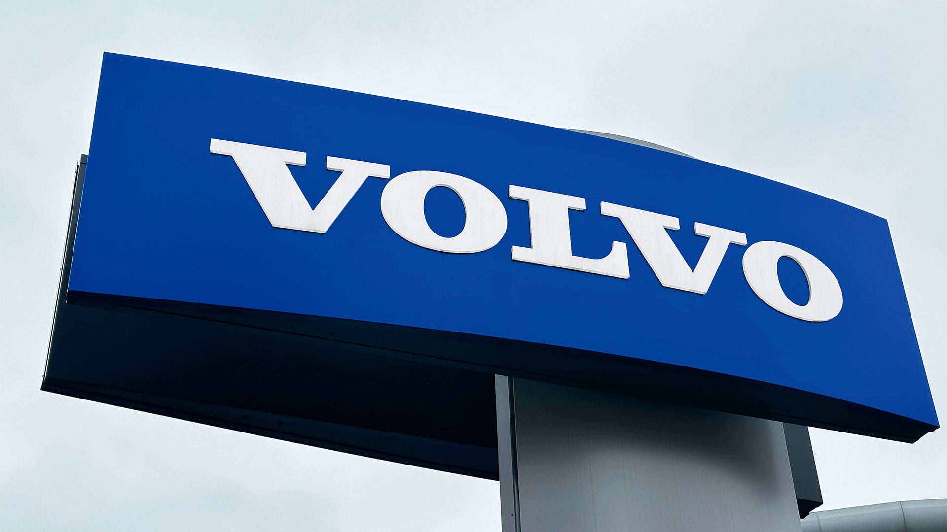 Blå Volvo Cars-skylt utanför återförsäljare.