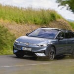 En silvergrå VW ID. 7 Tourer kör på en landsväg.