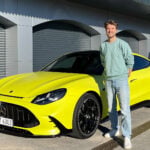John Sempill bredvid en gul Mercedes-AMG GT 4-Door på Ascari-banan.
