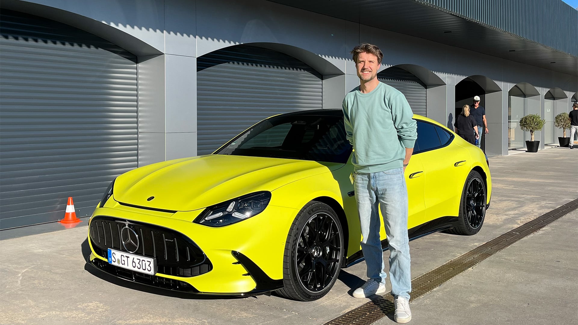 John Sempill bredvid en gul Mercedes-AMG GT 4-Door på Ascari-banan.