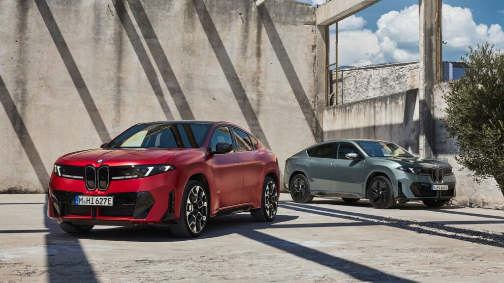 Röd BMW iX4 Neue Klasse till vänster och en grå till höger.
