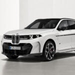 Vit BMW X5 snett framifrån i studio.